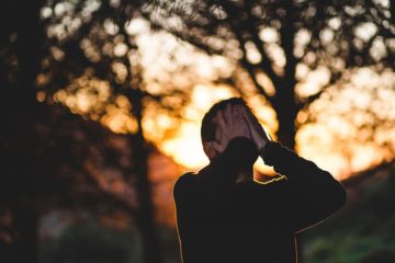 Man overwhelmed, standing outside.