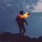 Man carrying burning torch at night.