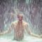 Man full of joy under waterfall